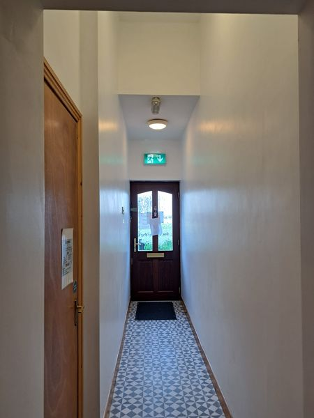 a hallway with a door and a tiled floor