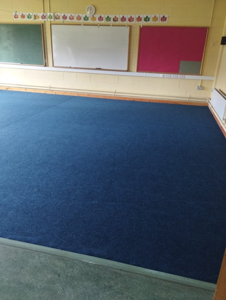 an empty classroom with blue carpet