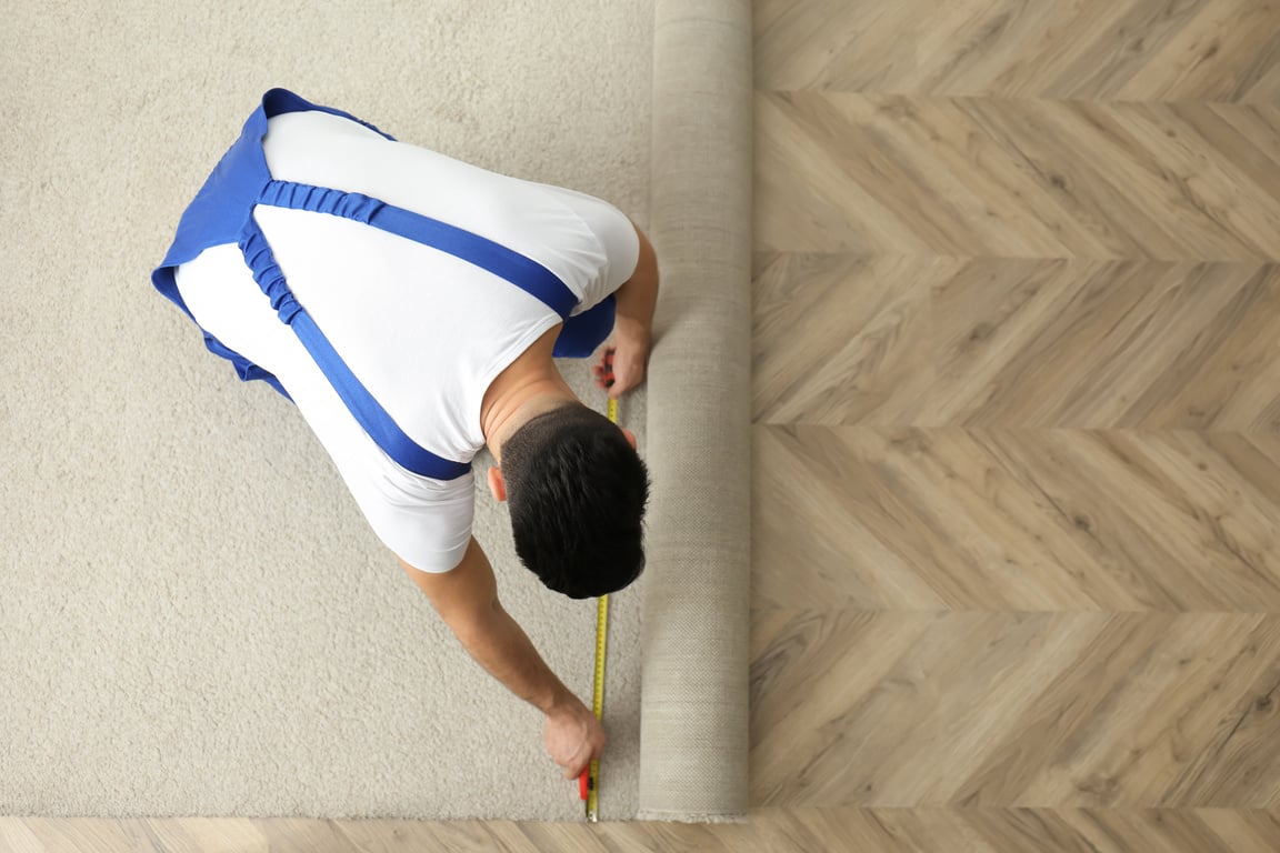 a person is measuring the length of a carpet