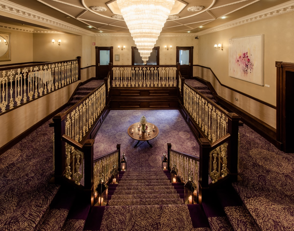 a staircase in a hotel with a chandelier hanging from the ceiling