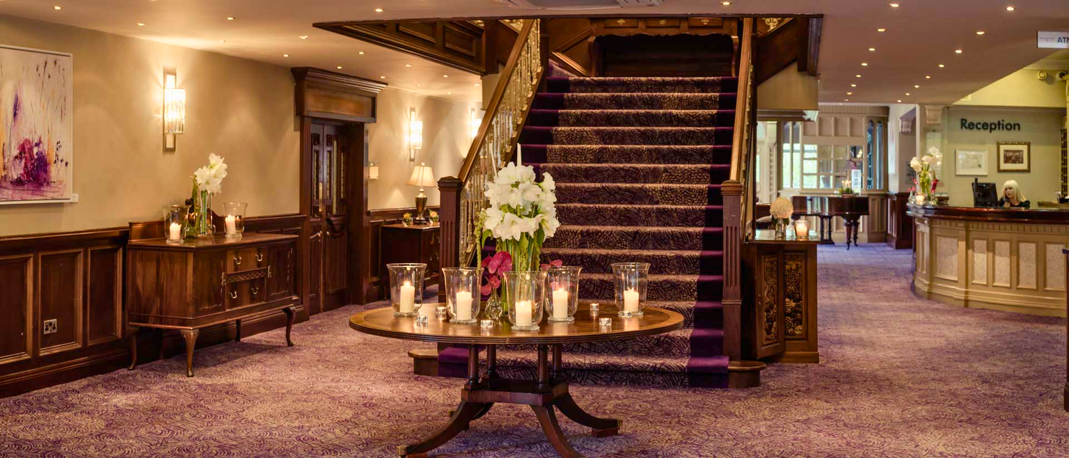 a hotel lobby with purple carpet and stairs