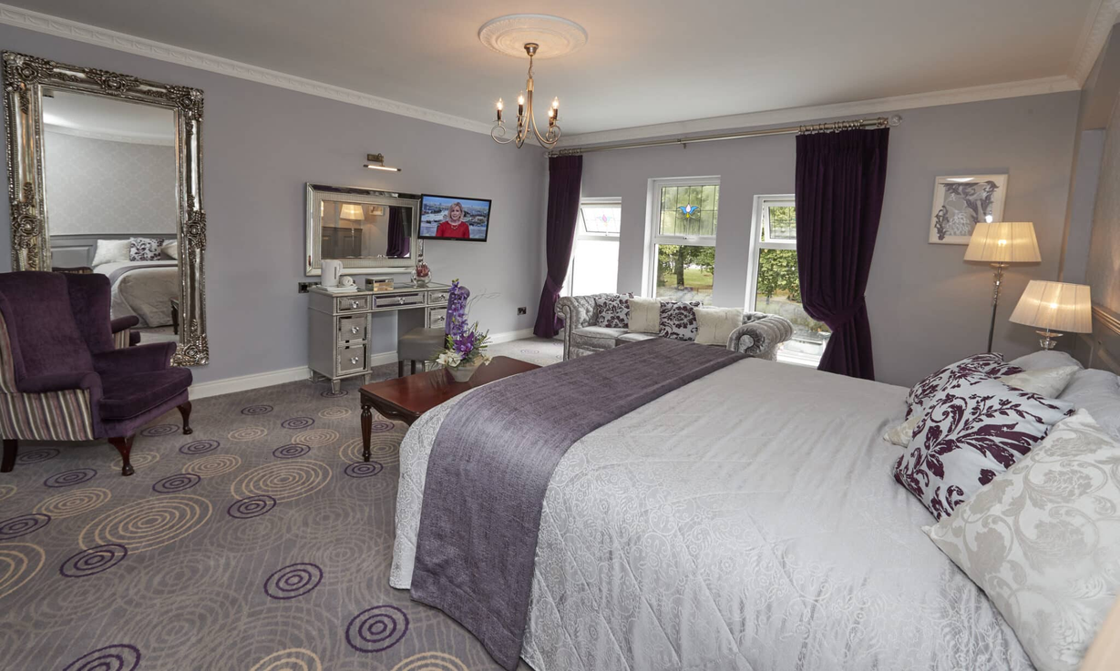 a large bedroom with purple and white decor