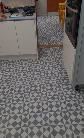 a kitchen with white and grey tiles on the floor