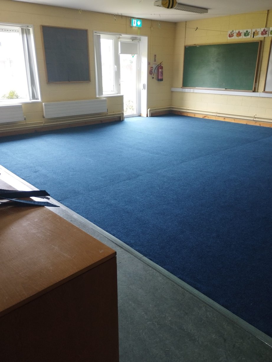 an empty classroom with blue carpet